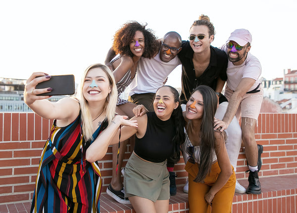 Group of friends taking a selfie with Noz colored sunscreen on their noses